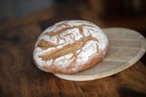 Rundes Brot auf Holzbrett vor der Verkostung und der Beschreibung mittels Sommeliersprache.