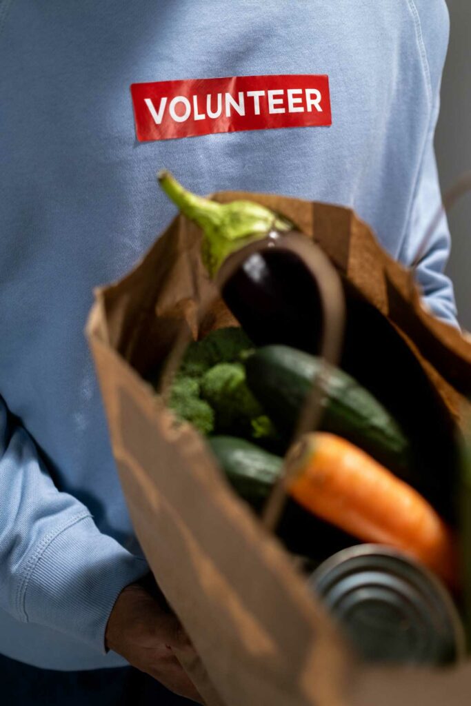 Person hält Papiertüte mit Lebensmitteln