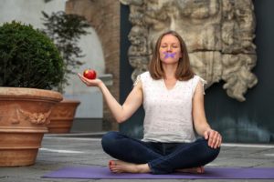 Frau meditiert mit geschlossenen Augen auf einer Yogamatte