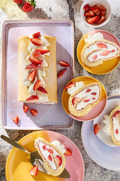 Rezeptfoto Erdbeerrolle auf bunten Tellern