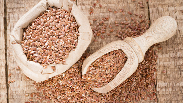 Leinsamen in einem kleinen Stoffsack mit Holzlöffel