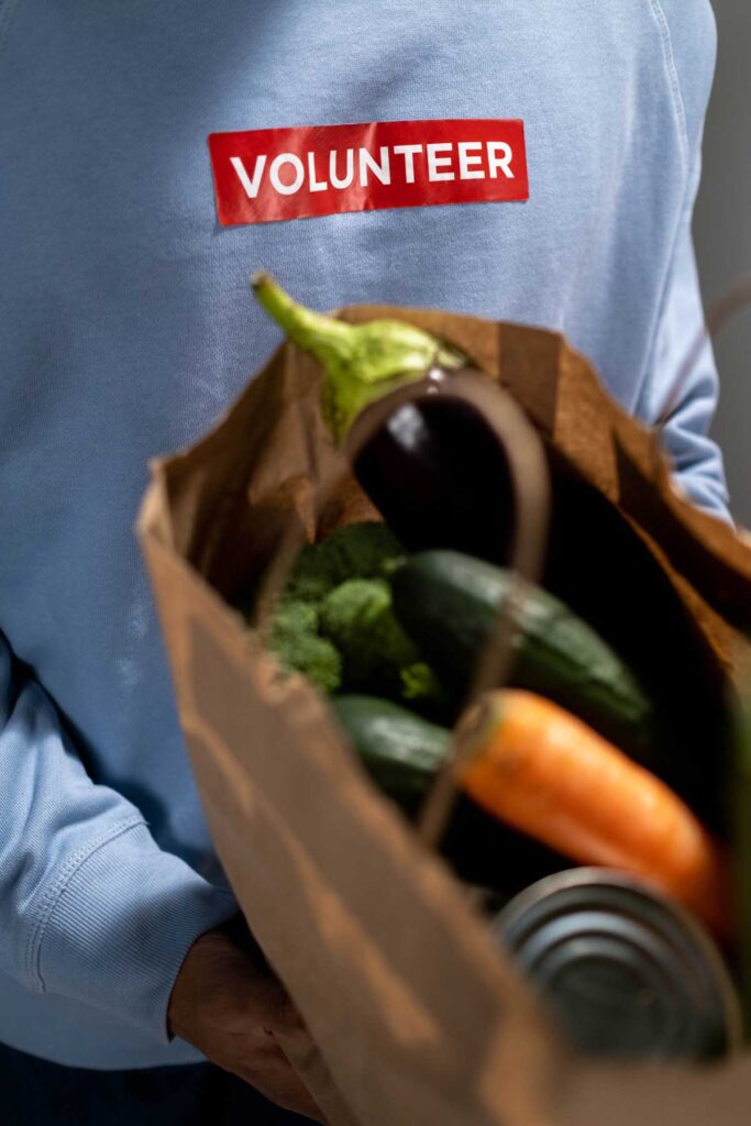 Person hält Papiertüte mit Lebensmitteln